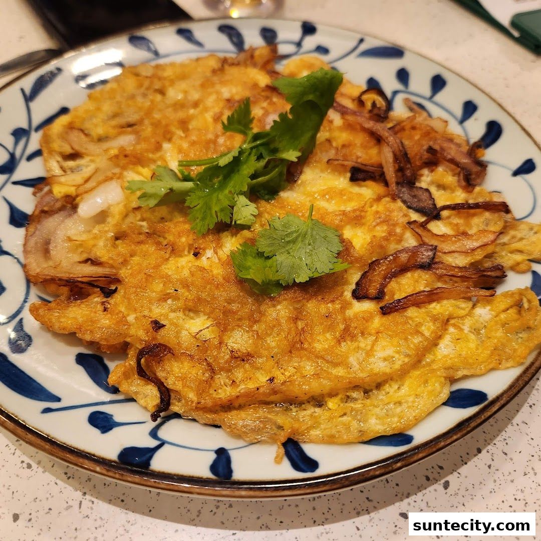 A plate of Indonesian omelette with fried onions and cilantro garnish.