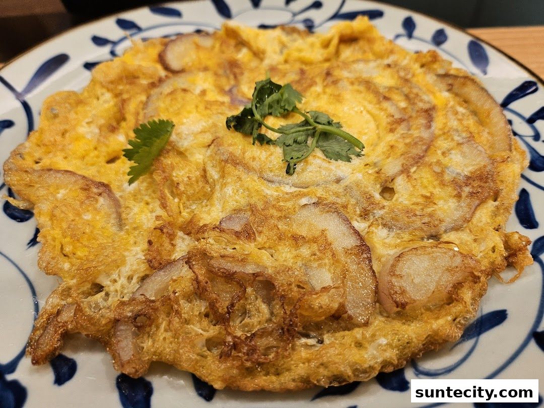 A close-up shot of a golden-brown omelet with visible onions, garnished with cilantro.
