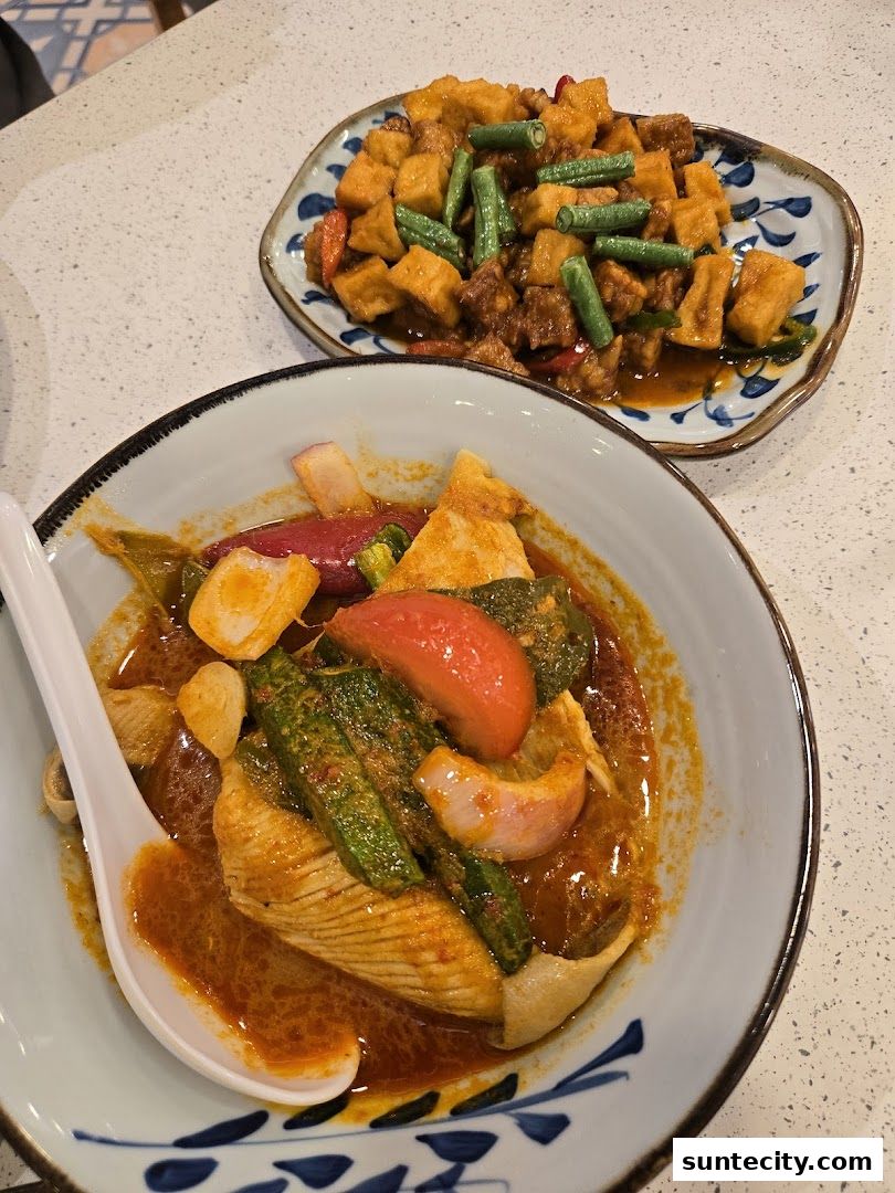 Two plates of Indonesian food, one with curry and vegetables, the other with tofu and green beans.