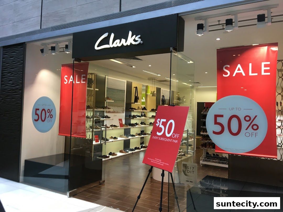 The entrance of a Clarks shoe store with 'SALE' banners and discounts displayed.