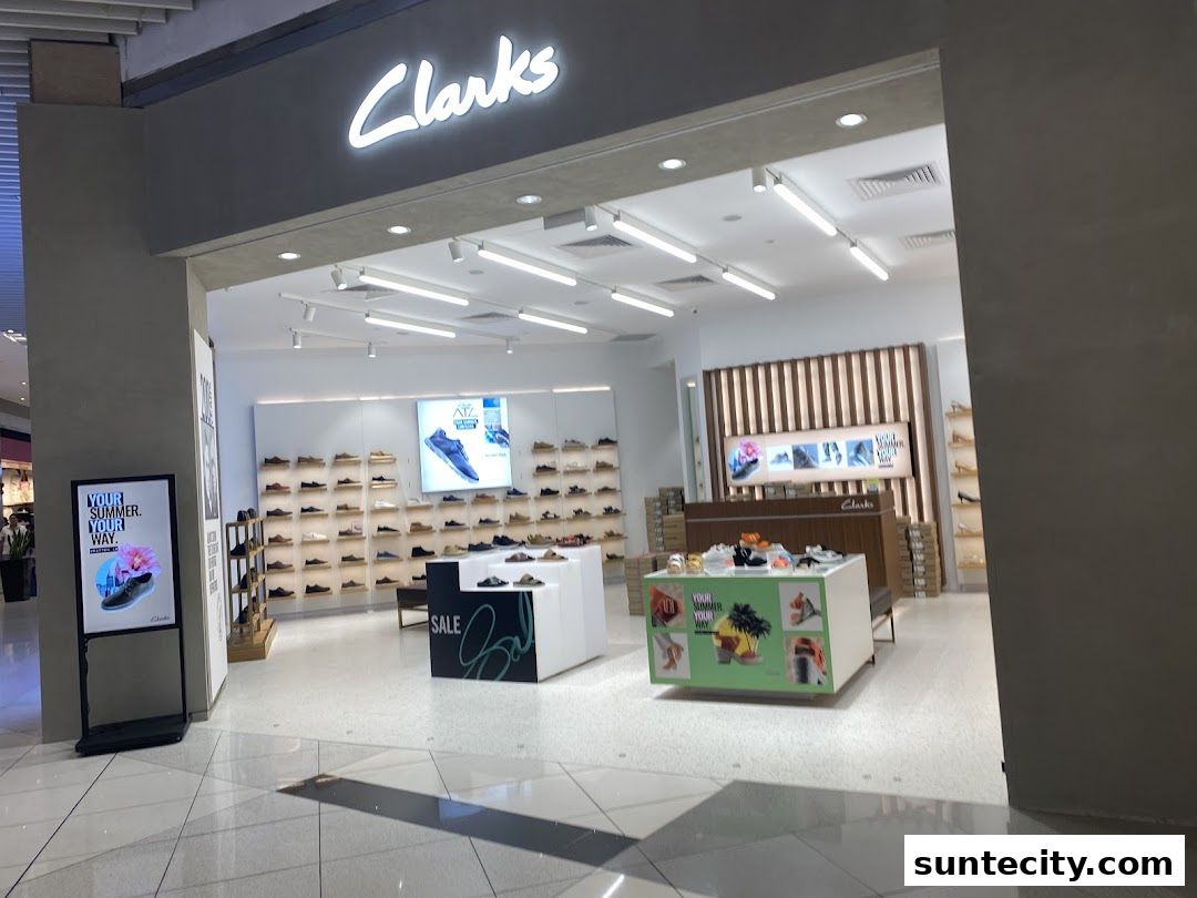 The entrance of a Clarks shoe store, showcasing various footwear and promotional displays.