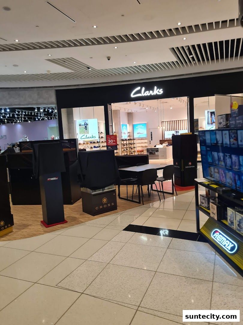 The exterior of a Clarks shoe store in a shopping mall, with displays of shoes and a 30% cashback offer.