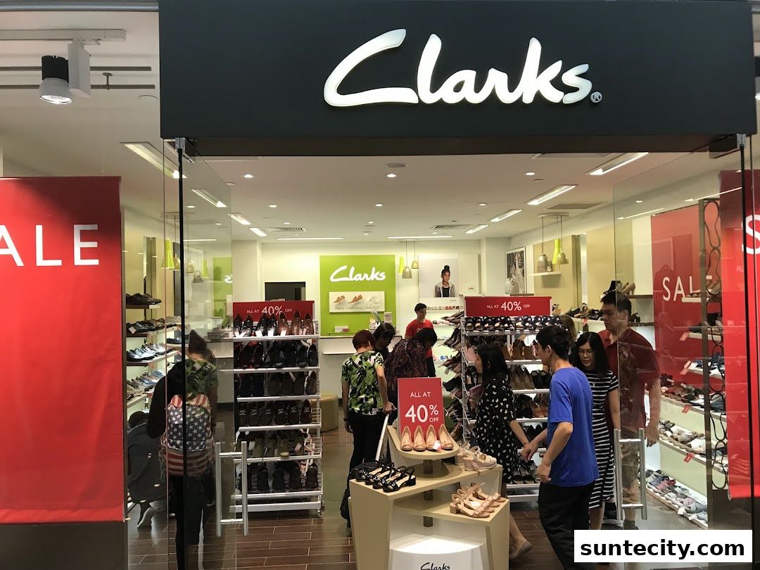 Clarks shoe store entrance with sale banners and customers browsing footwear.