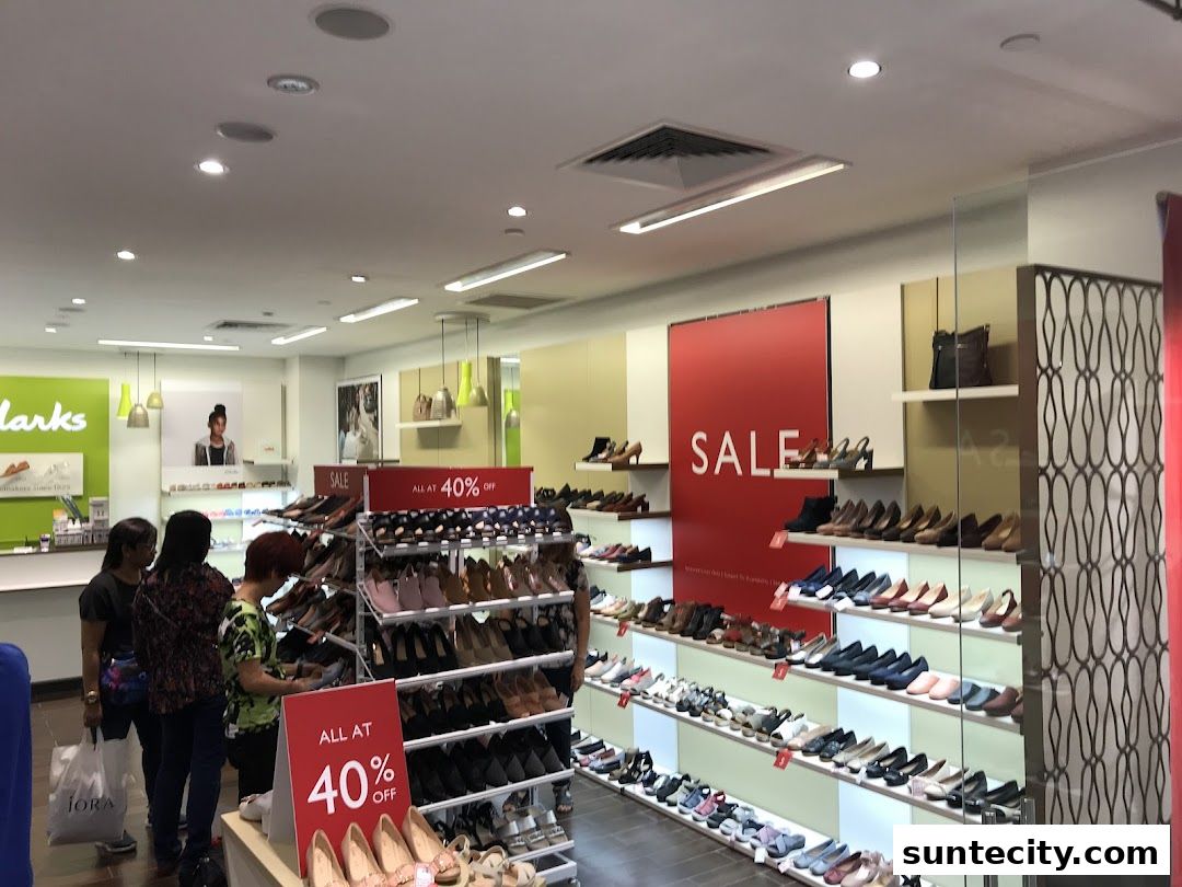 Interior view of a Clarks shoe store with a large sale display and numerous shoes on shelves.