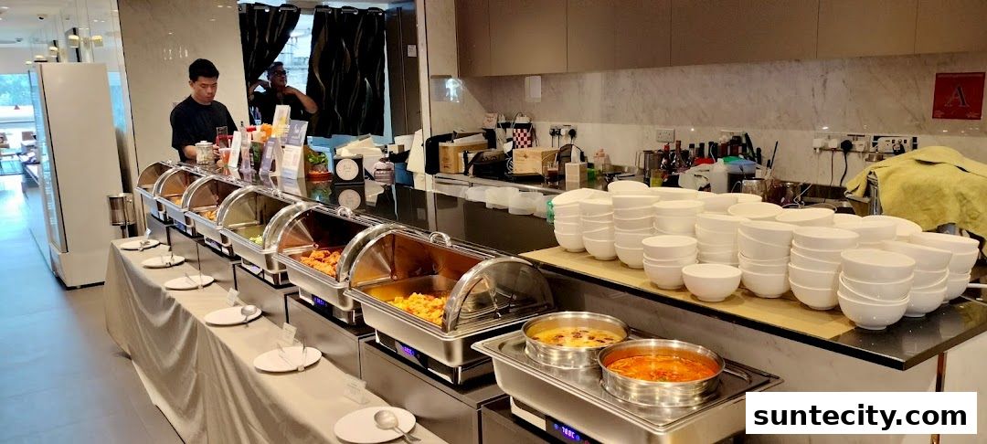A buffet spread with various dishes in chafing dishes and stacks of bowls.