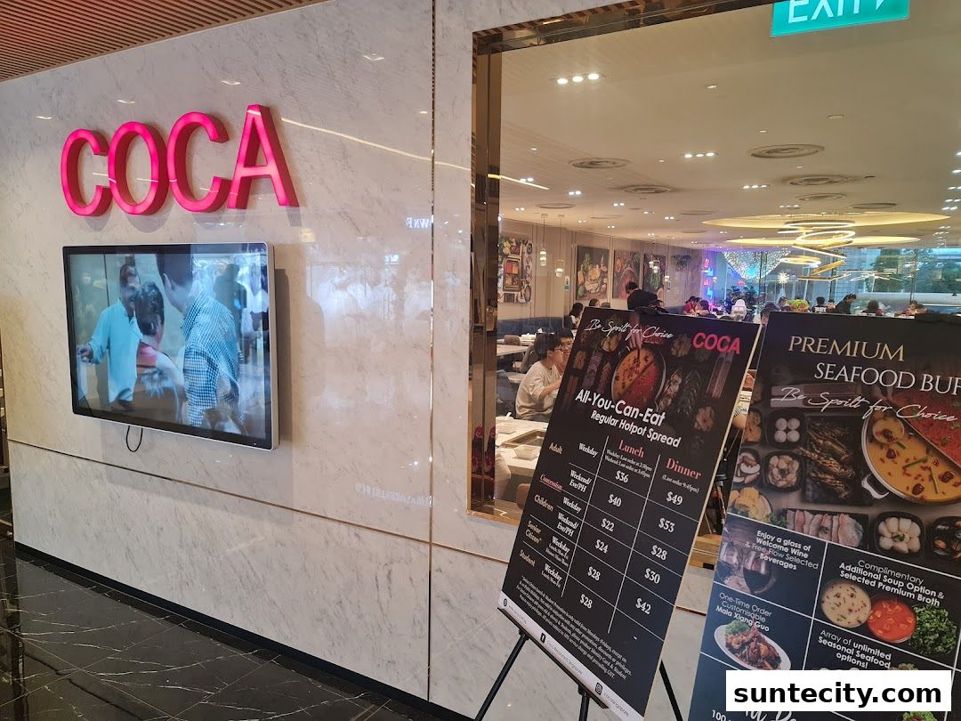 The entrance of COCA restaurant with a menu board displaying hotpot and seafood buffet options.