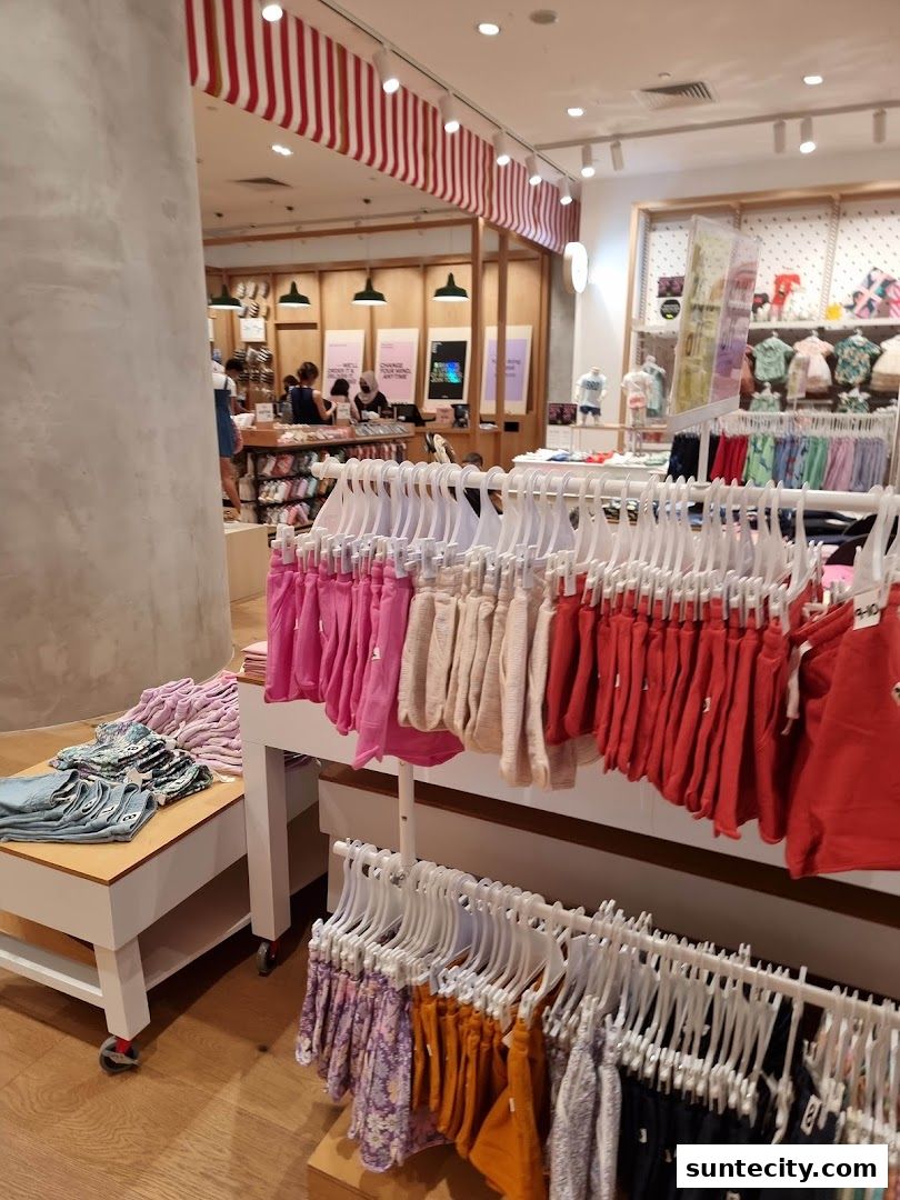 Interior view of a Cotton On store showcasing racks of colorful shorts and clothing.