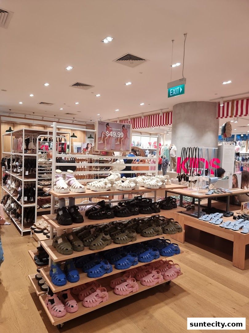 Interior view of a Cotton On store showcasing a wide selection of colorful sandals on display shelves.