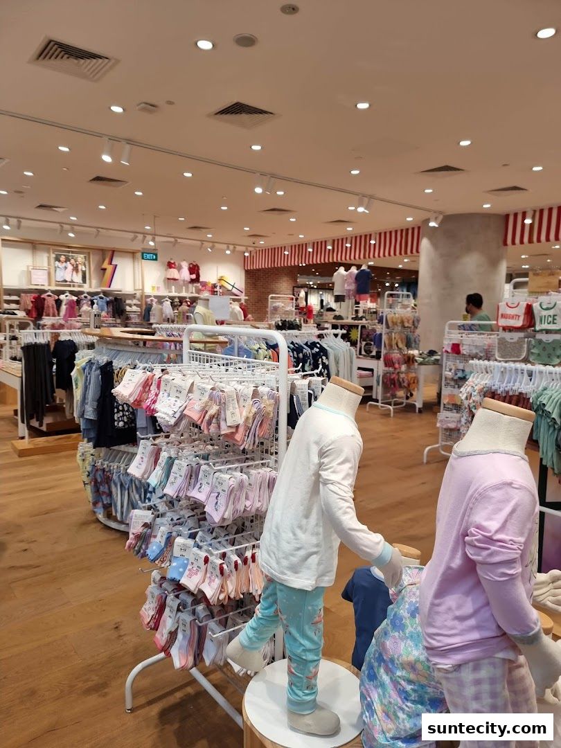 Interior view of a Cotton On store showcasing colorful socks, pajamas, and clothing on mannequins and racks.