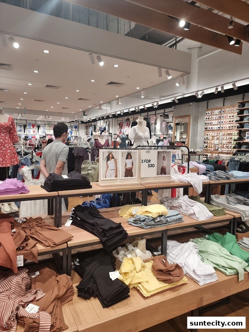 Interior view of a Cotton On store showcasing folded clothing on display shelves and mannequins.