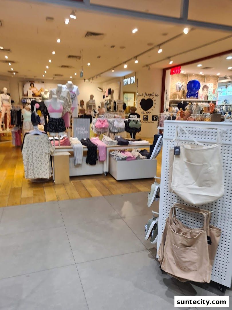 Interior view of a Cotton On store showcasing clothing on mannequins and racks, with bags displayed.