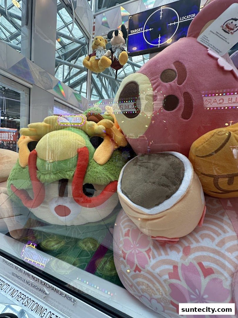 A claw machine filled with various plush toys, including Winnie the Pooh and Mickey Mouse.