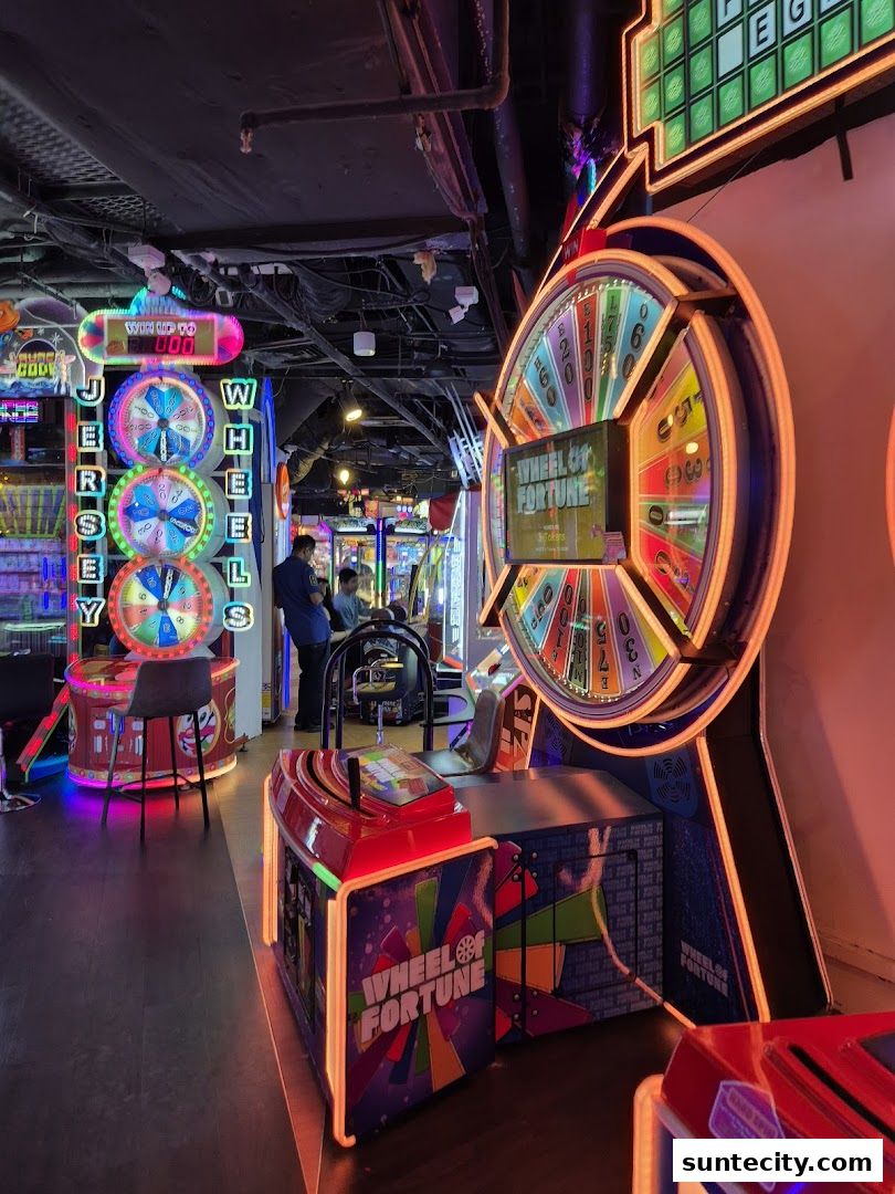 Brightly lit arcade with multiple game machines, including Wheel of Fortune.