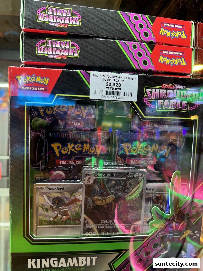 A display of Pokémon trading card game booster packs and a Kingambit illustration collection.