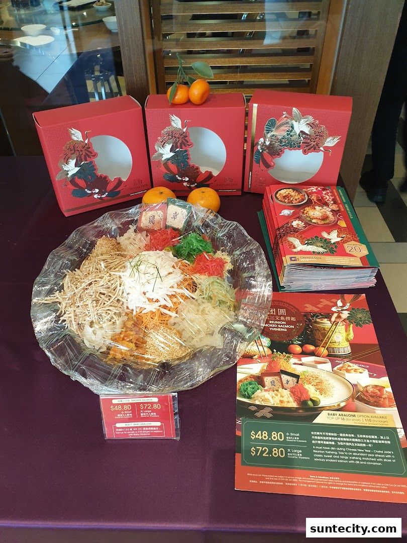 A festive display of Chinese New Year Yusheng with red gift boxes and oranges.