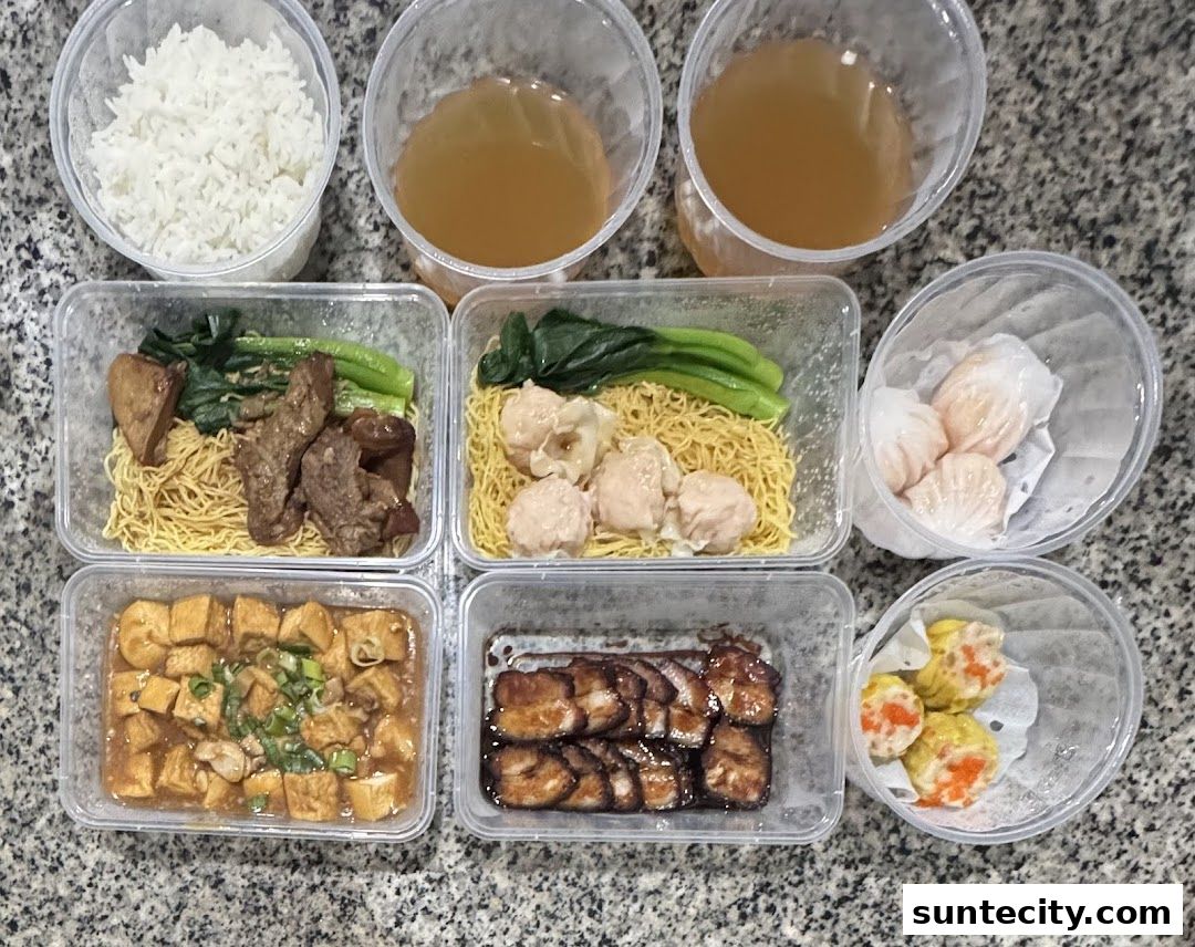A variety of delicious Hong Kong-style dishes, including noodles, dim sum, and roasted meats, are neatly arranged in takeaway containers.