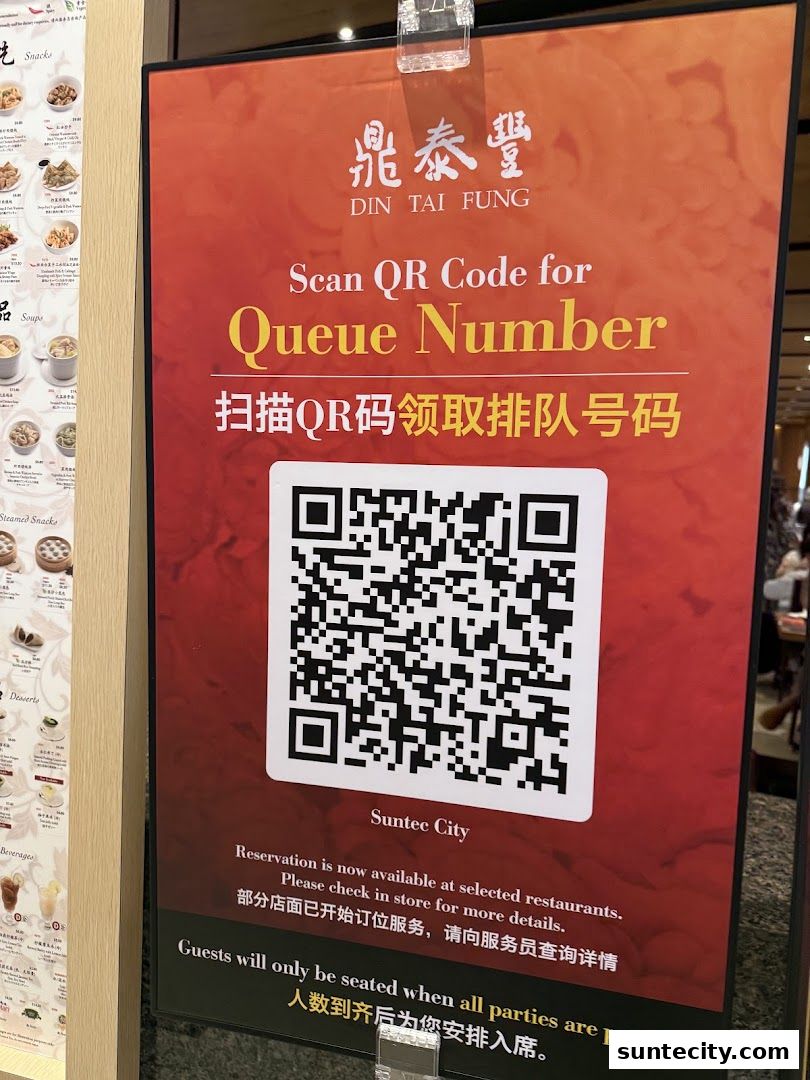 A sign at Din Tai Fung Suntec City instructs customers to scan a QR code for a queue number.