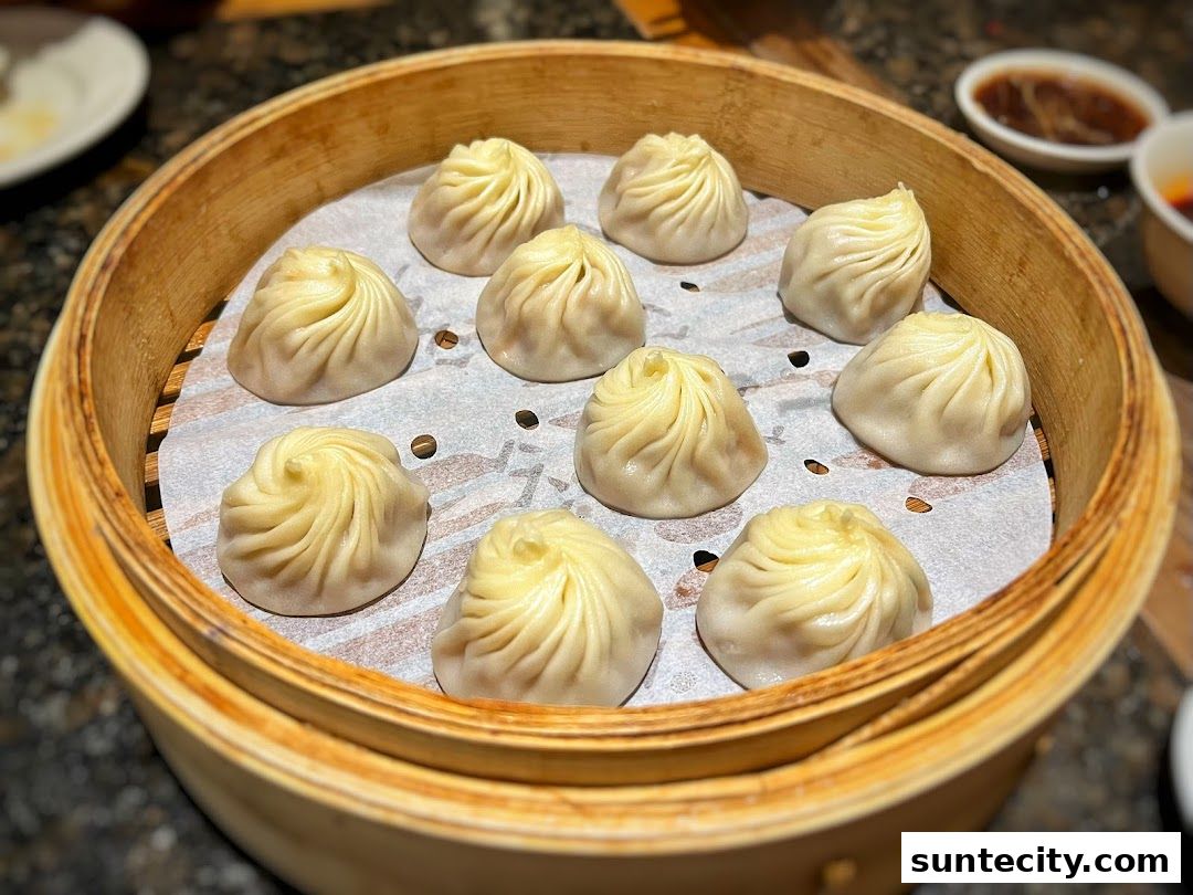 A close-up shot of steaming Xiao Long Bao dumplings in a bamboo steamer basket.