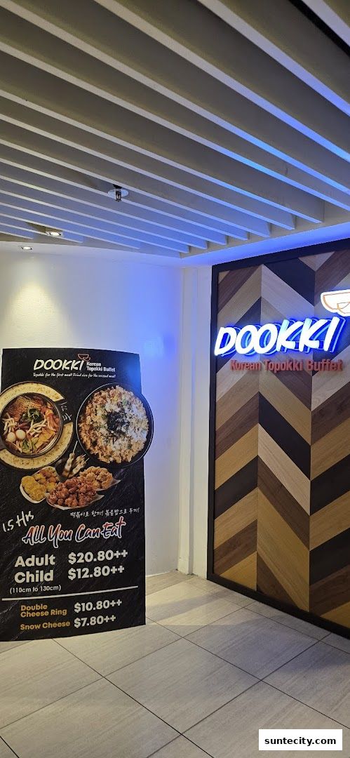 The entrance to Dookki, a Korean Topokki Buffet, with a promotional sign.