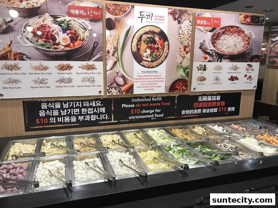 A display of various ingredients for Korean tteokbokki, including rice cakes and vegetables.