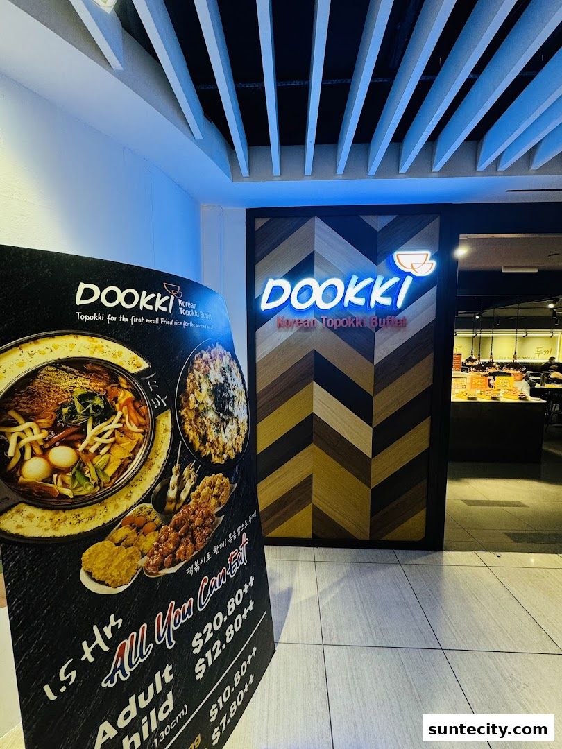 A sign for Dookki Korean Topokki Buffet with prices and images of food.