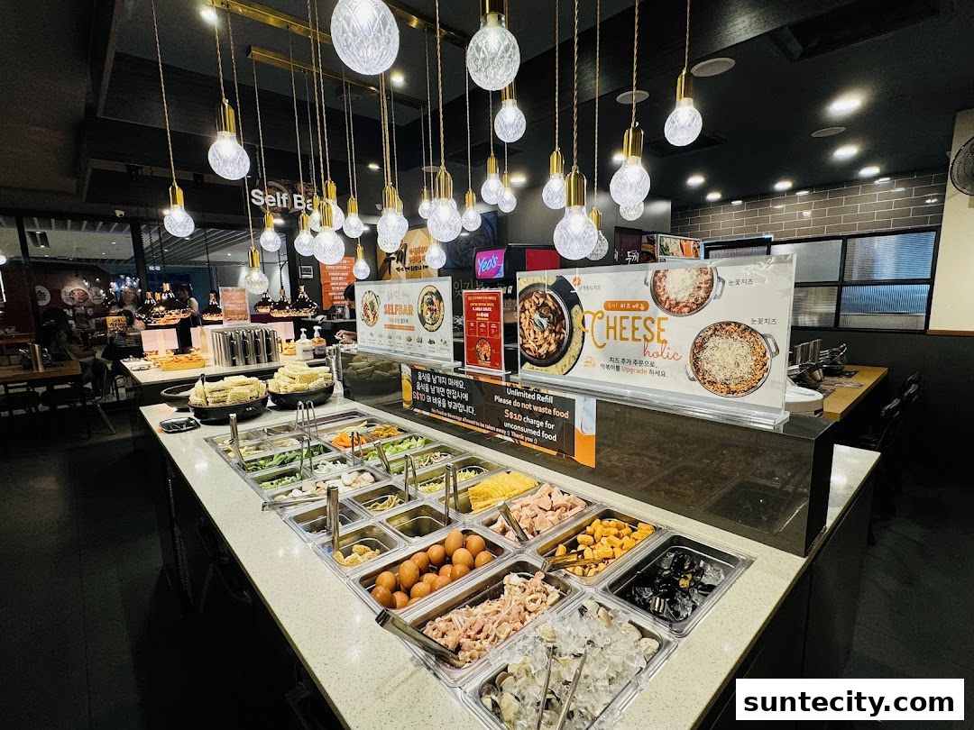 A self-serve bar with various ingredients for hot pot, including vegetables, meats, and seafood.