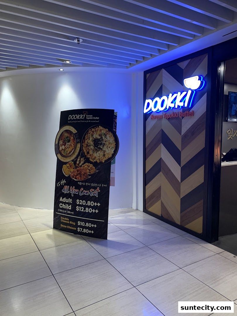 The entrance to Dookki, a Korean Topokki Buffet, with a promotional stand.