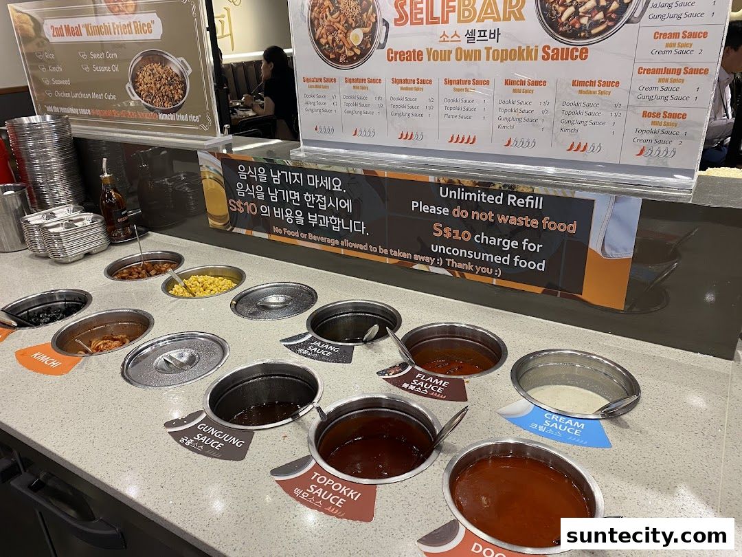 A self-serve bar with various sauces and toppings for Tteokbokki.