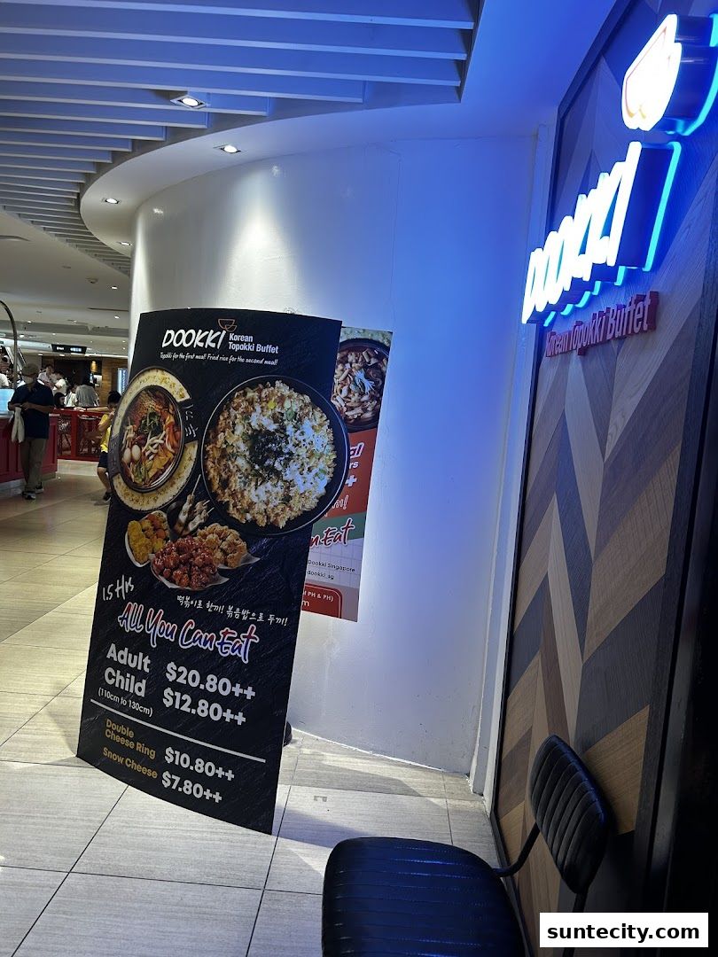 A sign for Dookki Korean Topokki Buffet with pricing and food images.