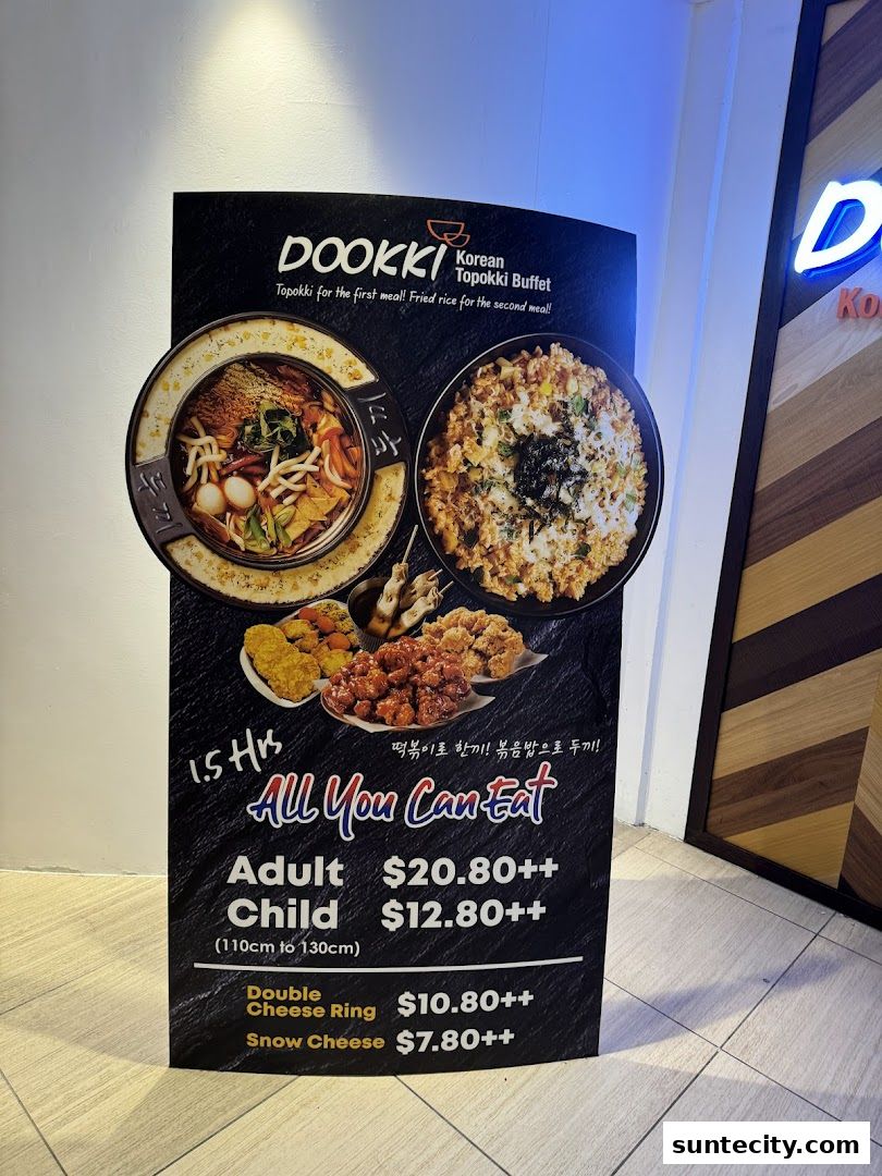 A sign advertising Dookki Korean Topokki Buffet with prices for all-you-can-eat options.