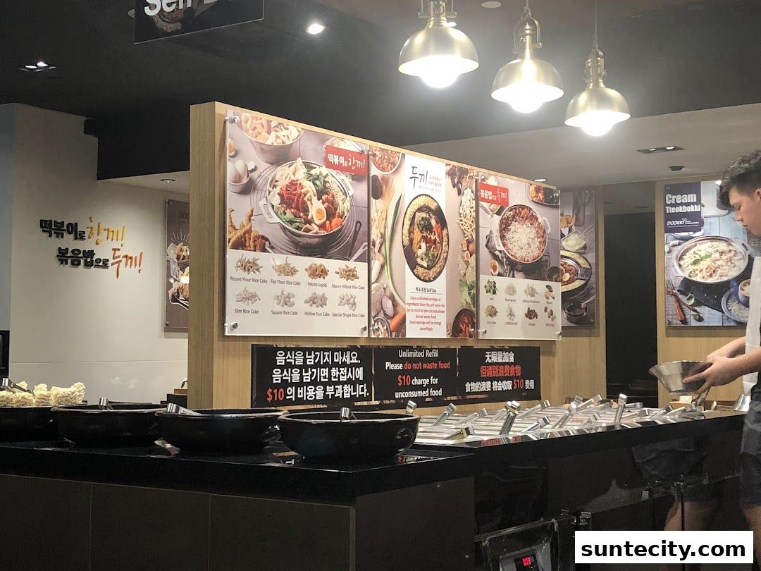 A display of Korean tteokbokki ingredients and menu boards inside a restaurant.