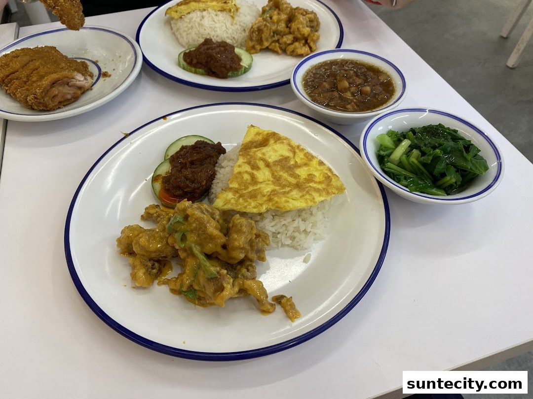 A table laden with delicious Asian cuisine, featuring rice dishes and side vegetables.