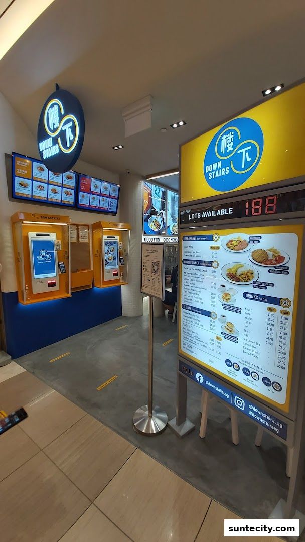The entrance of Downstairs restaurant with digital menus and ordering kiosks.