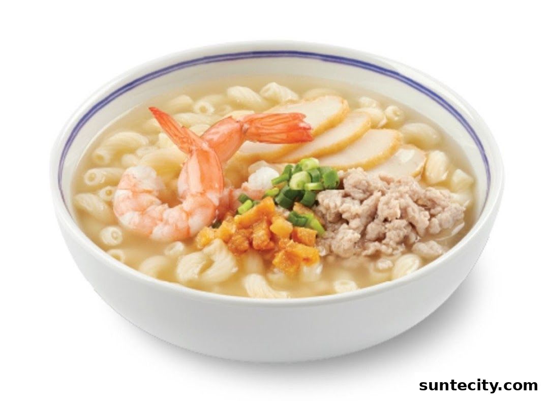 A bowl of macaroni soup with shrimp, minced pork, fish cakes, and chopped scallions.