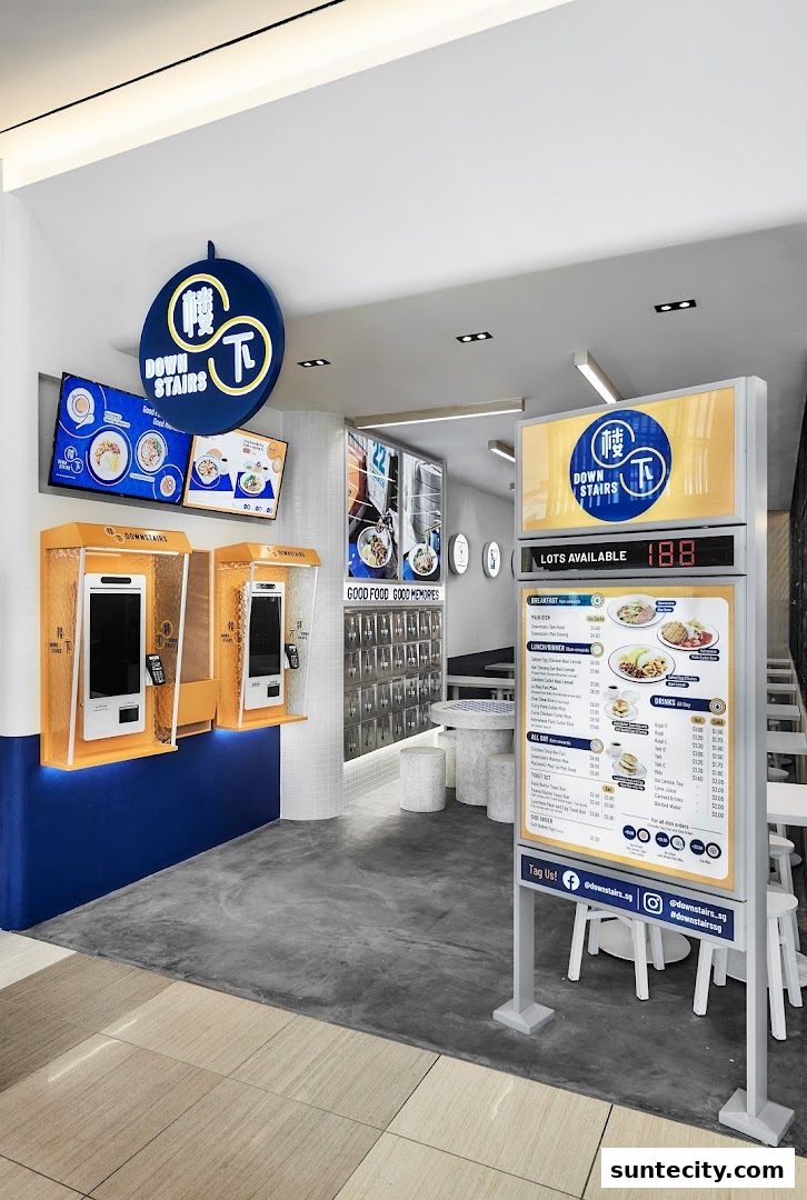The entrance of a modern eatery with digital menus and ordering kiosks.