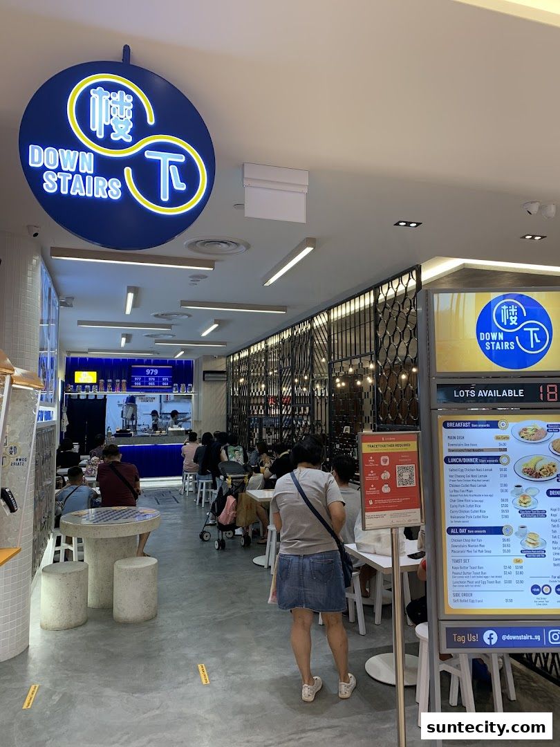 Interior of a restaurant with customers seated and a menu displayed on a stand.