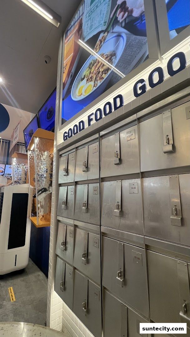 A wall of metal lockers with numbers, above a sign that says 'GOOD FOOD GOOD'.