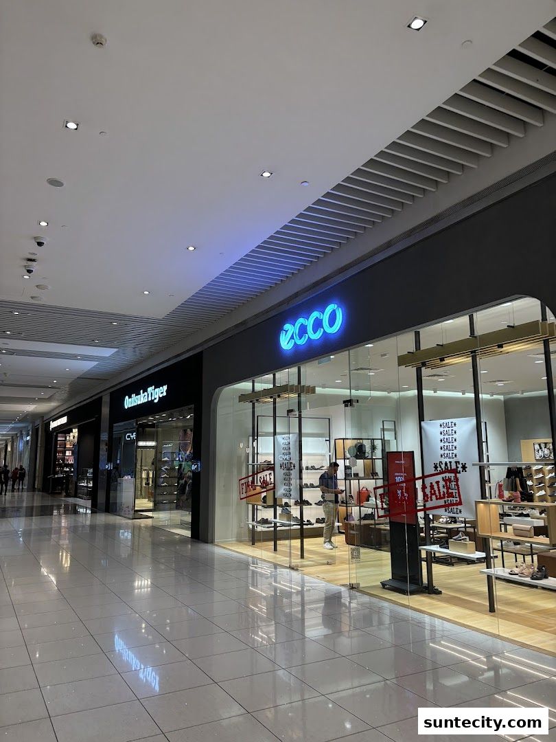The exterior of the ECCO shoe store in a shopping mall, showcasing footwear and sale signs.