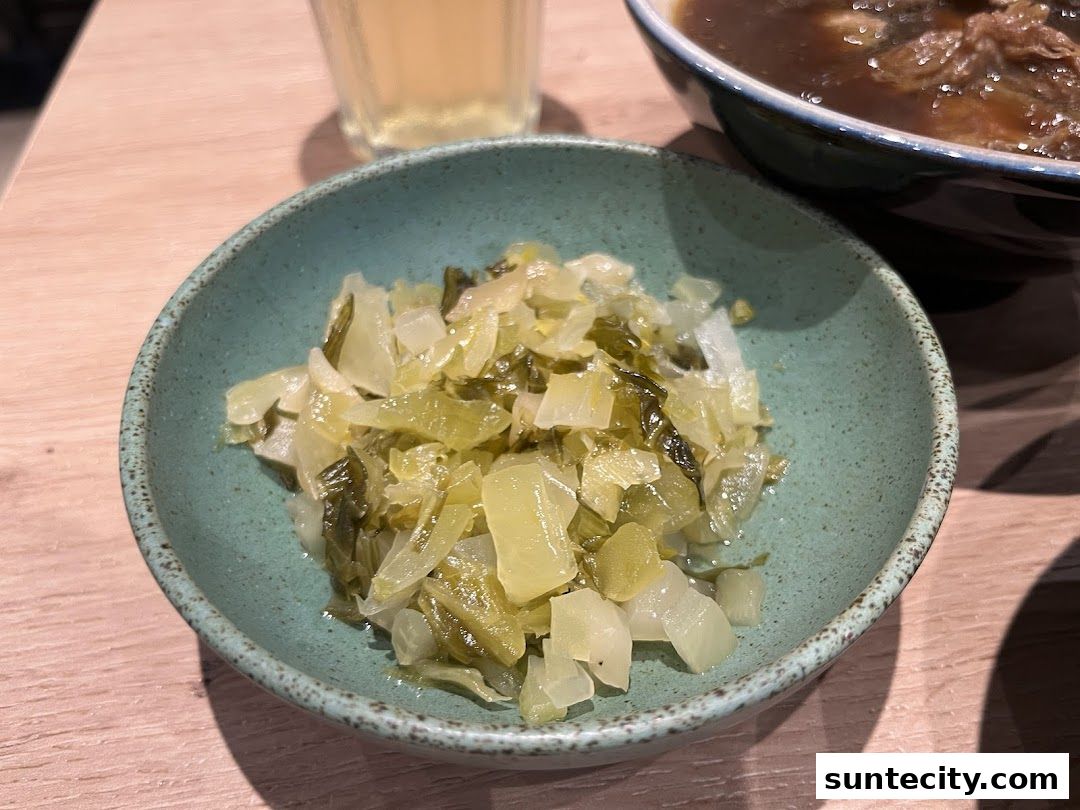 A close-up of a bowl of preserved mustard greens, a common side dish.