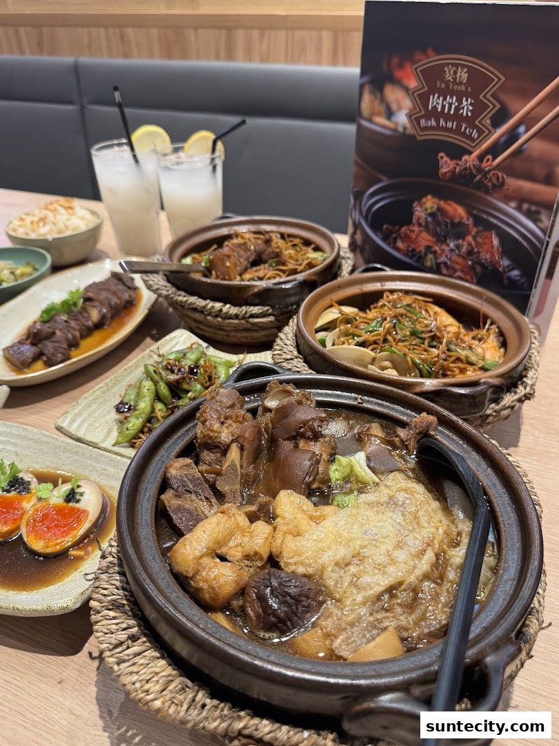 A table laden with delicious Bak Kut Teh, side dishes, and drinks.