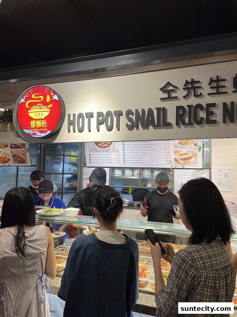 Customers queue at a food stall offering hot pot snail rice noodles and other Asian dishes.