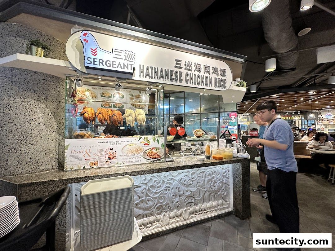 A food stall selling Hainanese chicken rice with roasted chickens displayed.