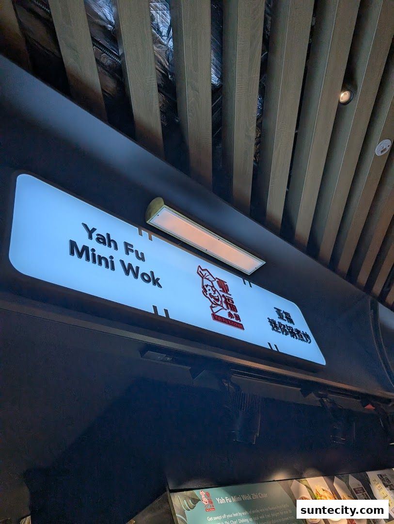 A lit sign for 'Yah Fu Mini Wok' with a cartoon chef logo and Chinese characters.