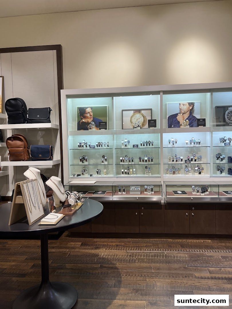 Interior view of a Fossil store showcasing watches and bags displayed in illuminated cabinets.