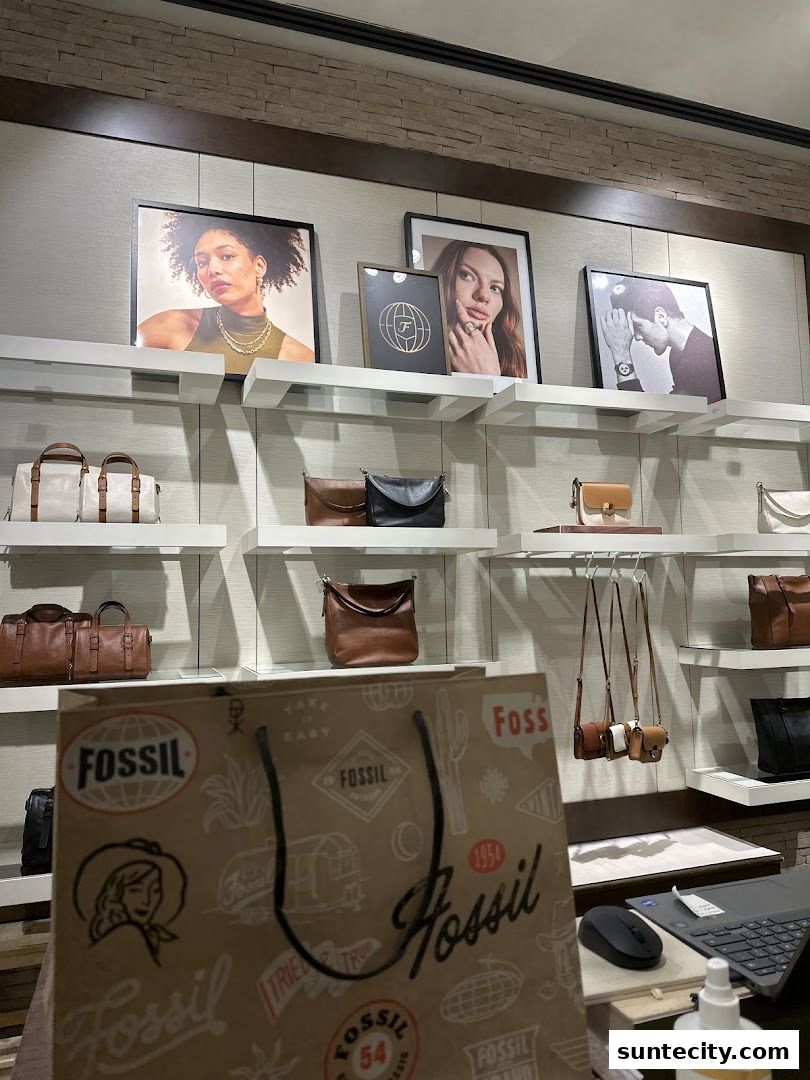 Fossil store interior showcasing handbags and accessories with lifestyle imagery.