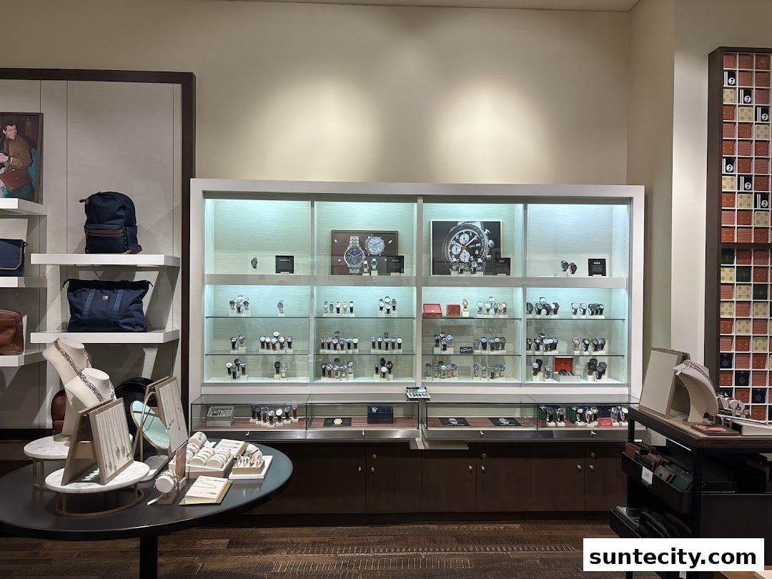 Interior view of a Fossil store showcasing watches and bags in display cases.