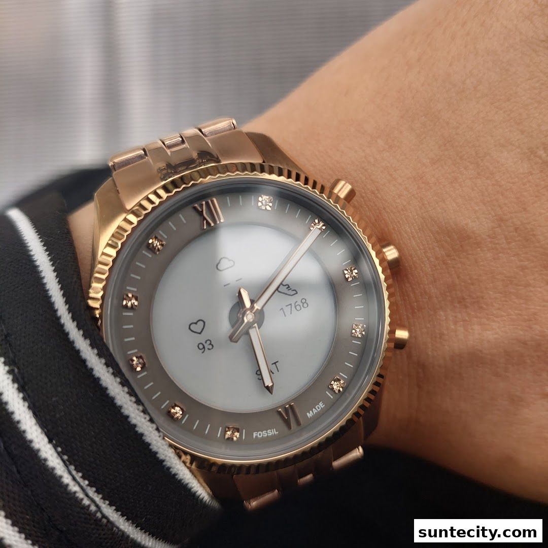 A close-up shot of a rose gold Fossil smartwatch on a person's wrist.