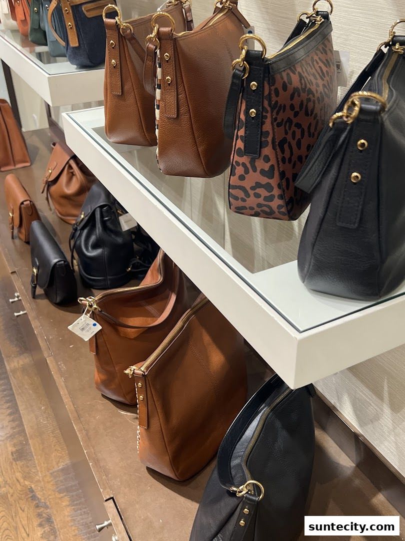 A display of various leather handbags in different colors and patterns.