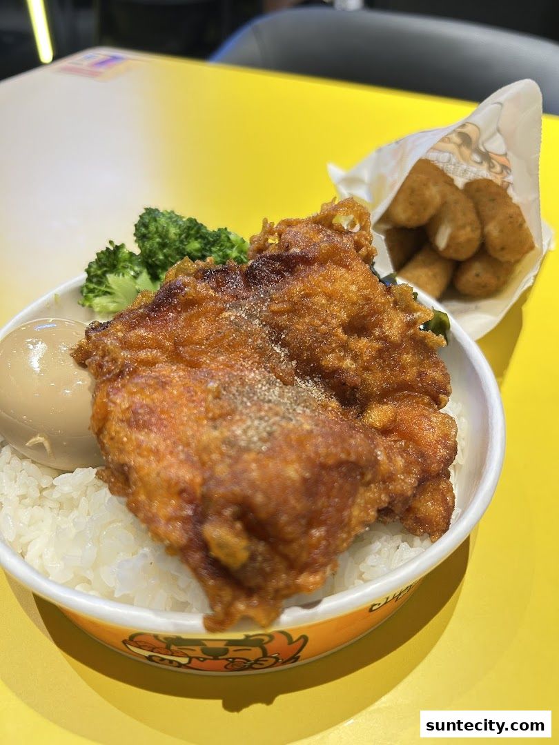 A delicious fried chicken meal with rice, broccoli, and cheese sticks.