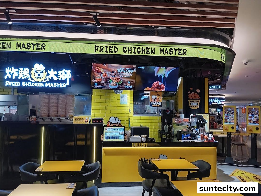 The interior of a Fried Chicken Master shop with yellow and black decor, seating, and a counter.
